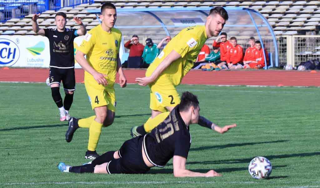 Czterech mężczyzn na boisku, jeden leży