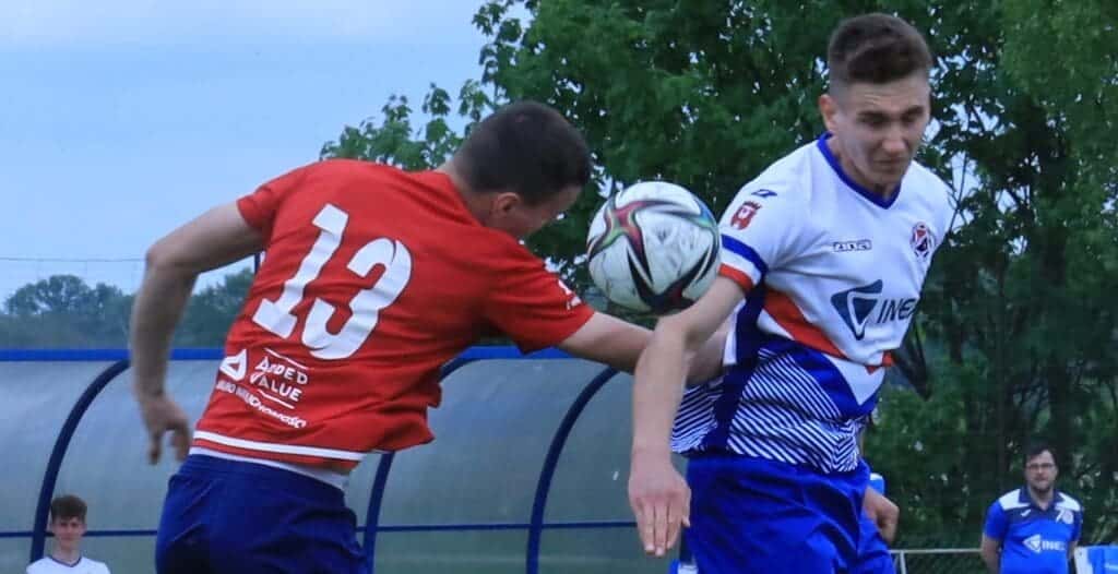 Dwóch mężczyzn walczy o piłkę