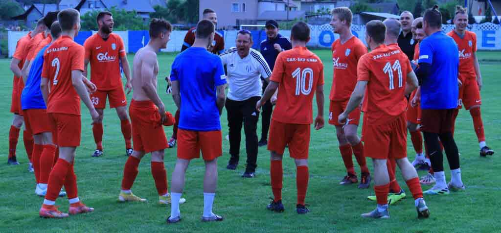 Grupa cieszących się mężczyzn na boisku