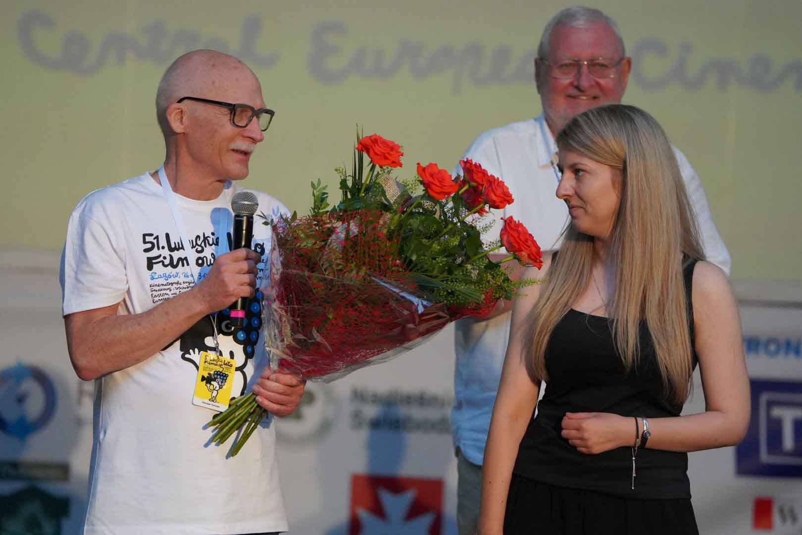 6 Kobieta i dwóch mężczyzn jeden trzyma bukiet kwiatów Finał Lubuskiego Lata Filmowego w Łagowie Ukraiński reżyser dziękuje z frontu w Donbasie ZDJĘCIA