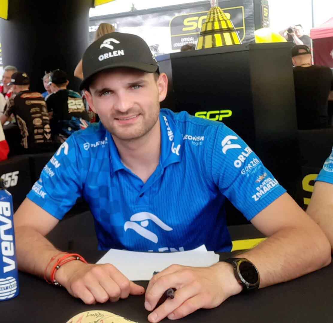 Mężczyzna przy stoliku  Bartosz Zmarzlik  mistrz mistrz mistrz