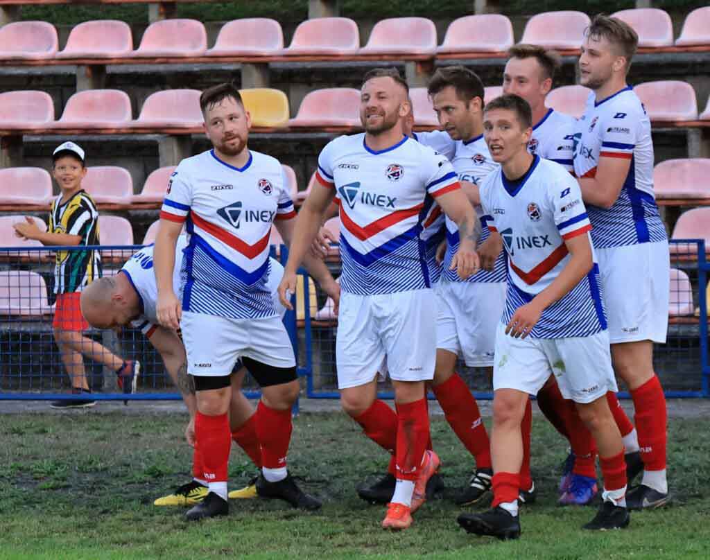 Ośmiu cieszących się piłkarzy na boisku