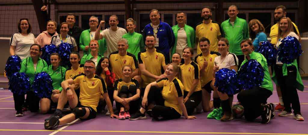 29 uśmiechniętych osób w hali sportowej