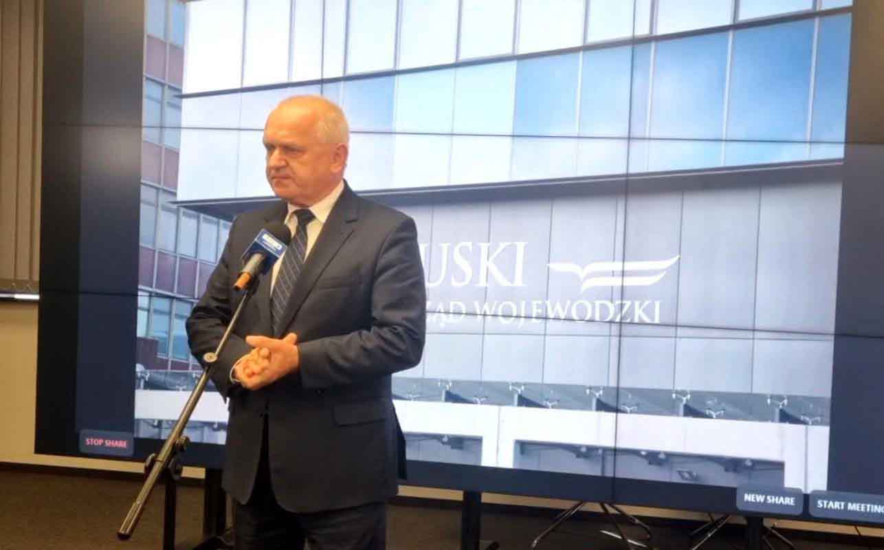 Mężczyzna w garniturze przy mikrofonie  Kibice wejdą na stadion na mecz Falubazu Zielona Góra z Wilkami Krosno