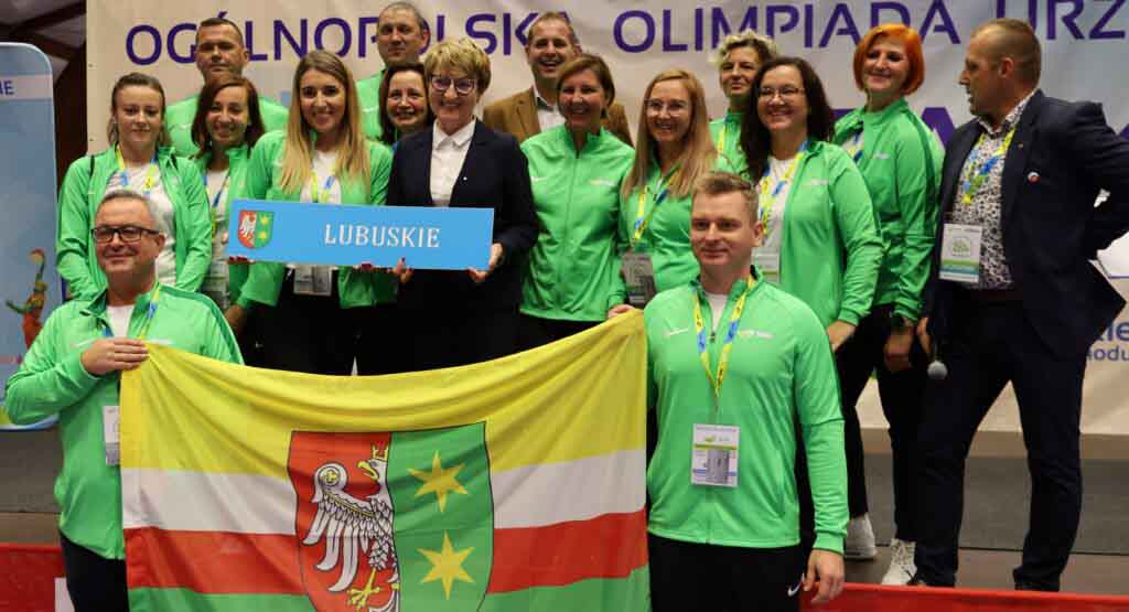 Kilkanaście osób w sportowych strojach i z flagą