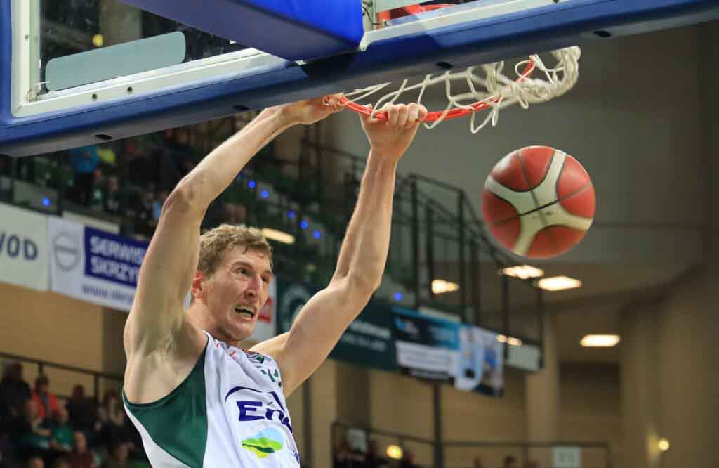 Mężczyzna wiszący na obręczy kosza