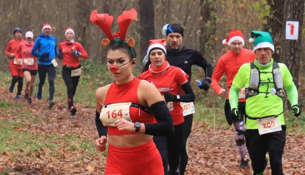 Dziesięć biegnących osób. Niektóre w czapkach Świętego Mikołaja