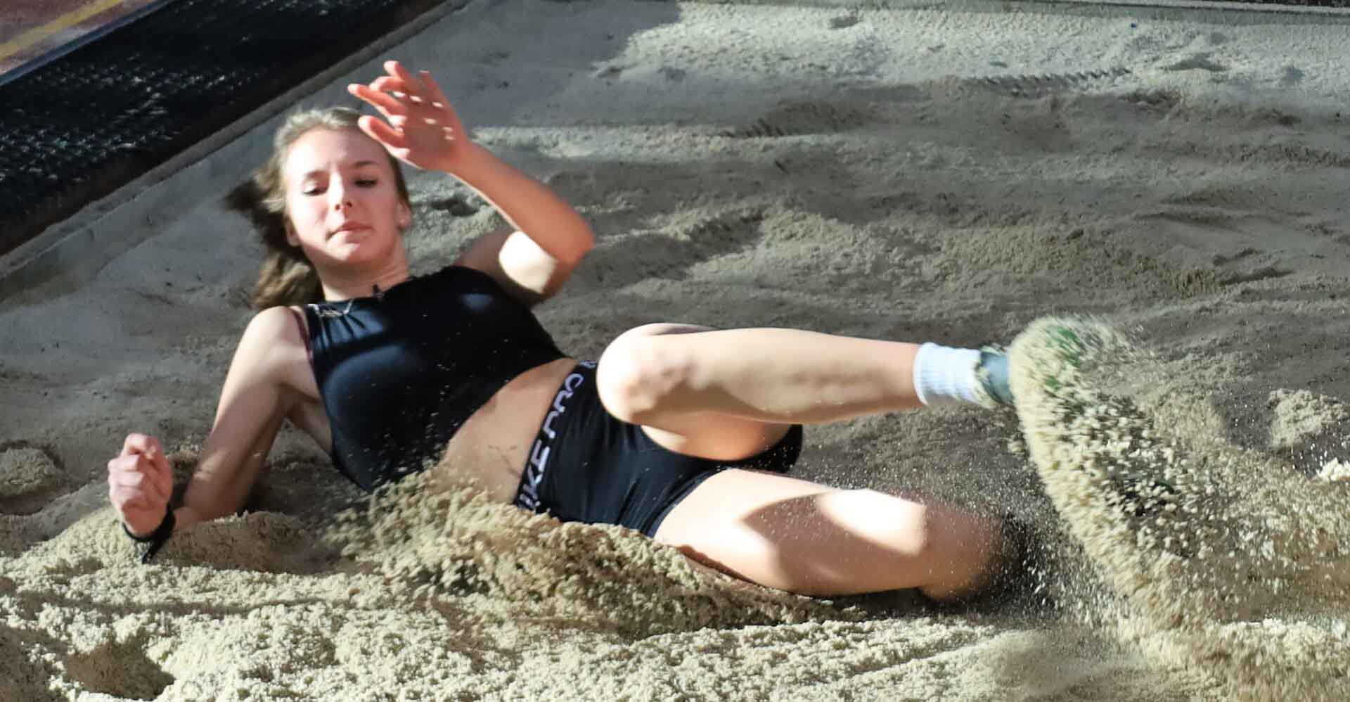 Dziewczyna lądująca w piaskownicy po skoku w dal  Sylwestrowy mityng w Zielonej Górze Sezon halowy się rozkręca ZDJĘCIA