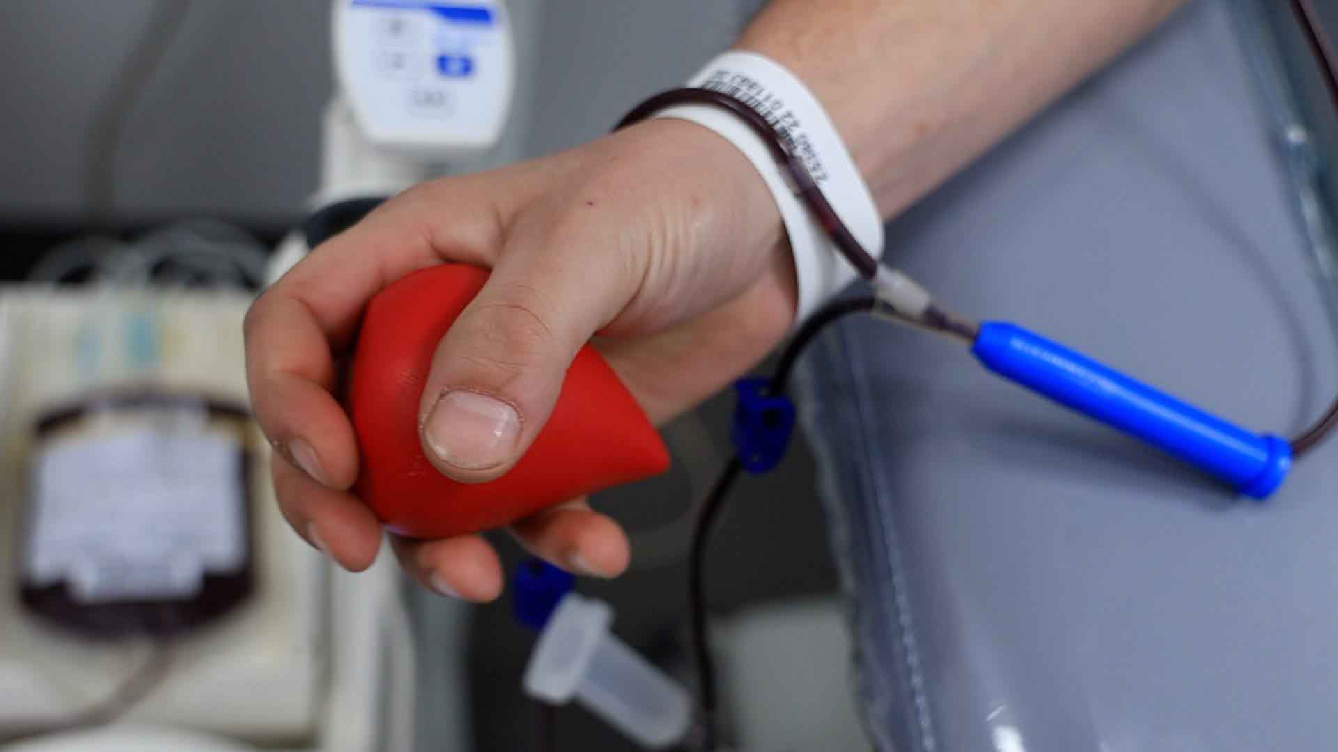 Ręką krwiodawcy ściskająca piłkę  Pilnie potrzebna krew