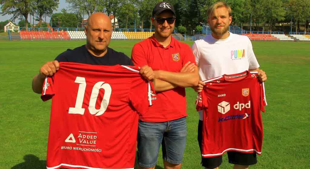 Trzech mężczyzn, dwóch trzyma sportowe koszulki