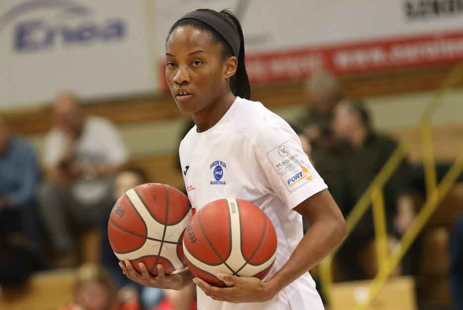 Kobieta niosąca dwie piłki do koszykówki