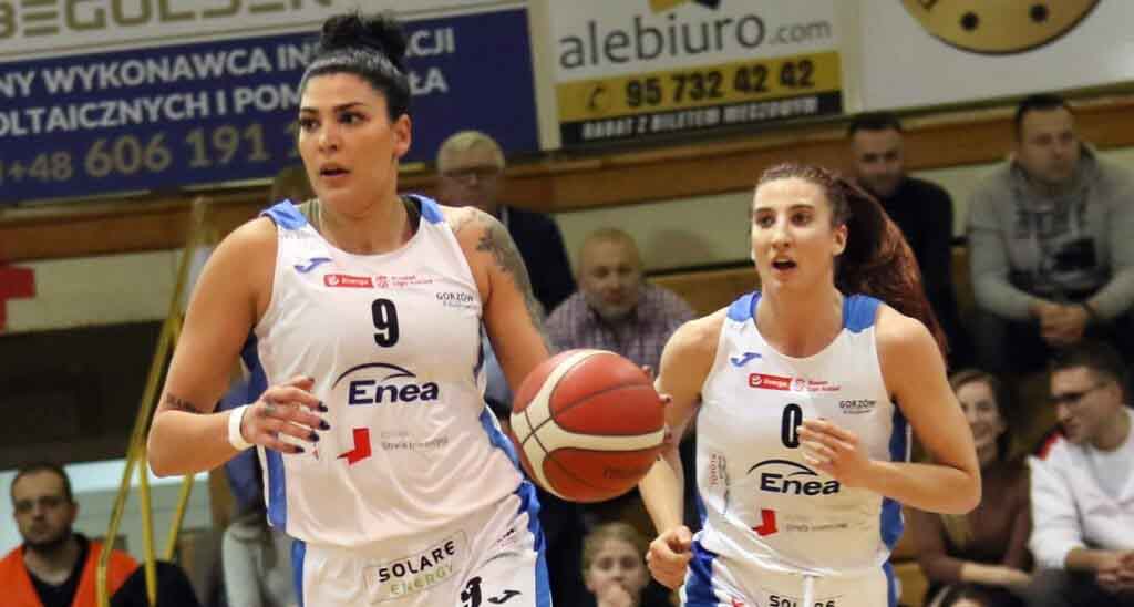 Dwie kobiety w sportowych strojach, jedna kozłuje piłkę