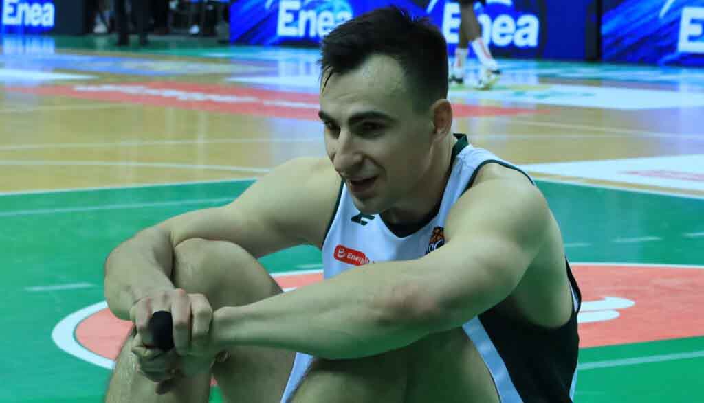 Sportowiec siedzący na parkiecie