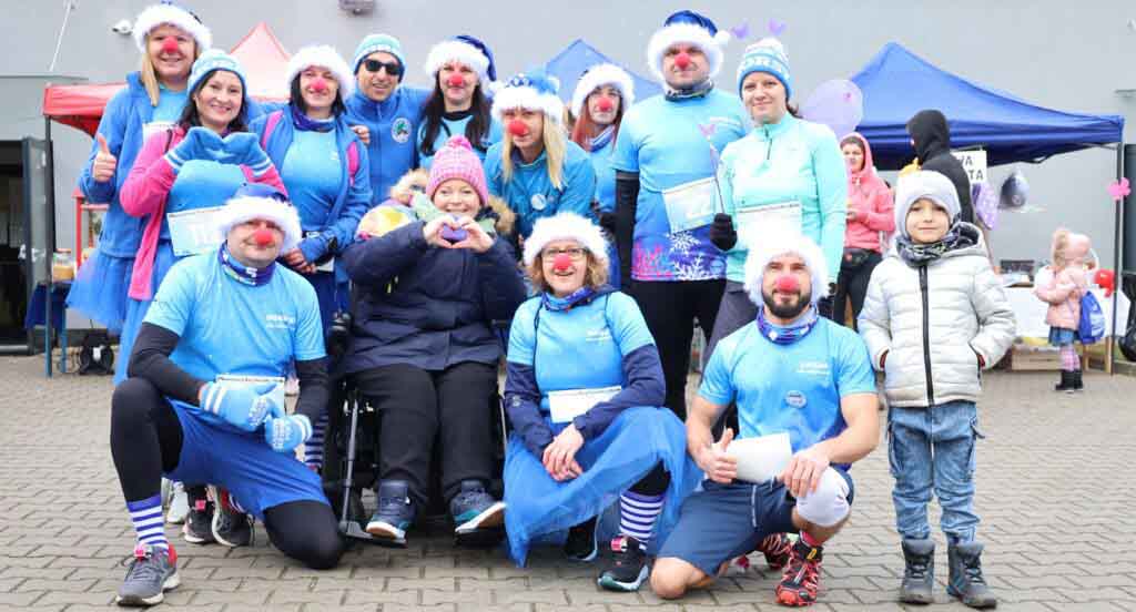 Grupa uśmiechniętych osób w sportowych strojach