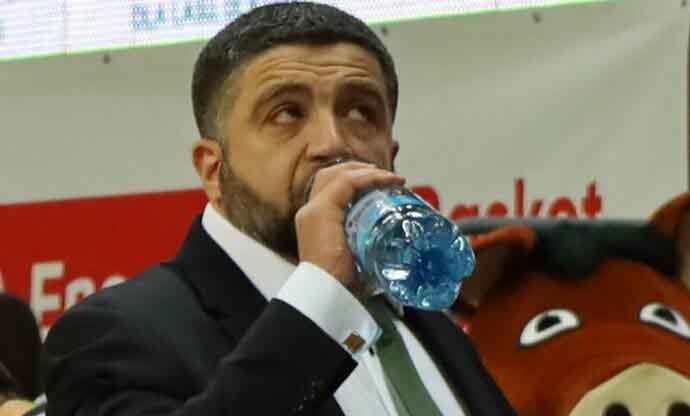 Mężczyzna w garniturze, pijący wodę z butelki