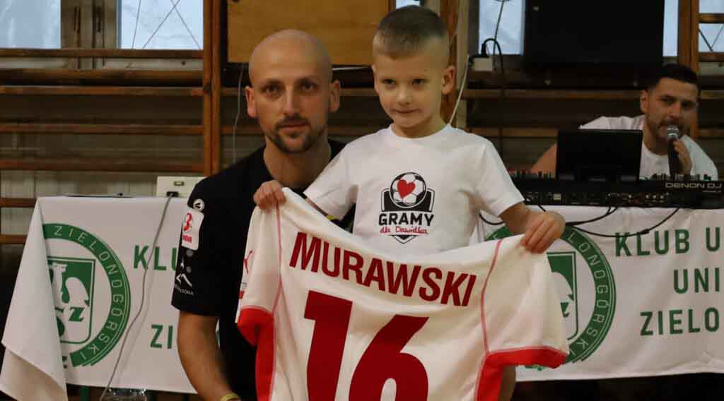 Mężczyzna z dzieckiem prezentującym sportową koszulkę