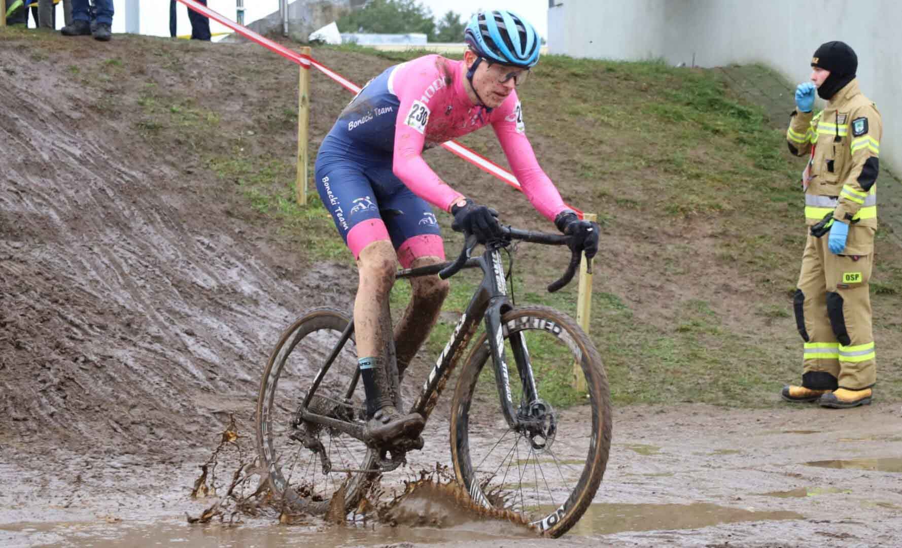 Ubłocony chłopak na rowerze  Ksawery Adaszak walczy na mistrzostwach świata