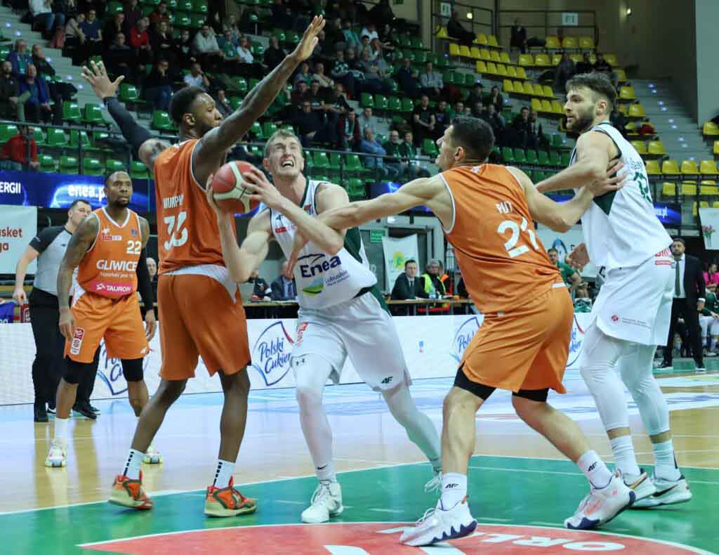 Pięciu mężczyzn w sportowych strojach, jeden trzyma piłkę