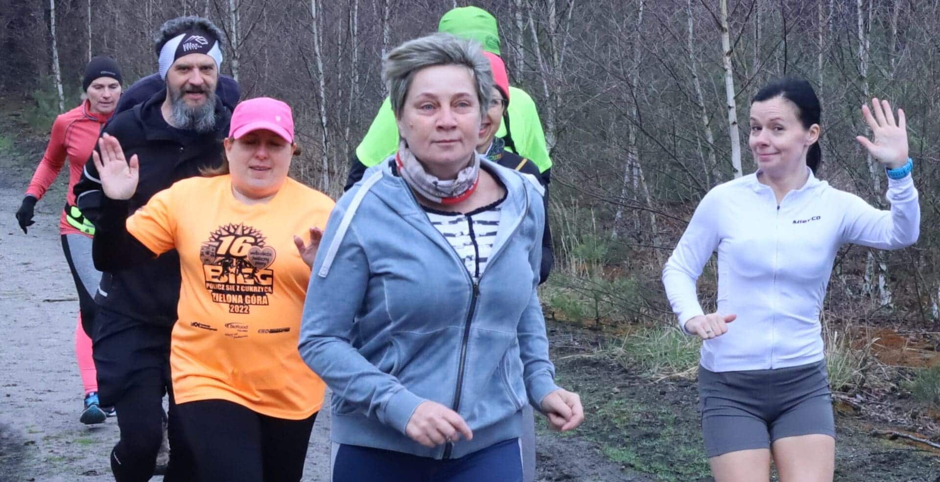 Grupa osób biegnących leśną drogą  Wielkanocny parkrun w Zielonej Górze w międzynarodowym towarzystwie ZDJĘCIA