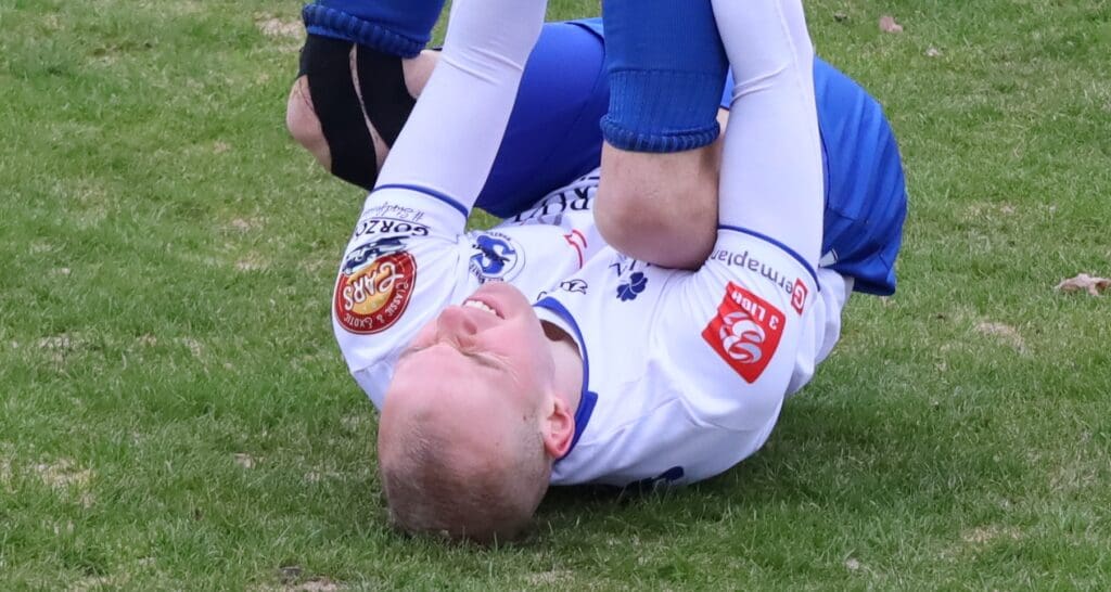 Mężczyzna leżący na boisku