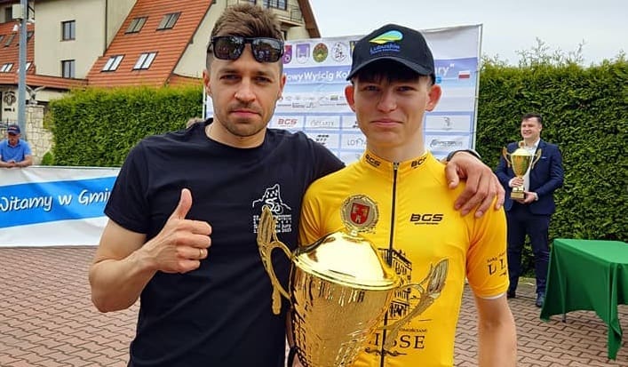 Mężczyzna z młodym sportowcem trzymającym puchar