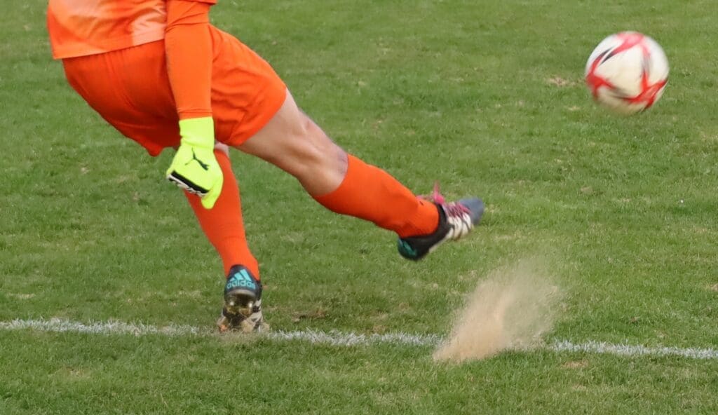 Zawodnik kopiący piłkę
