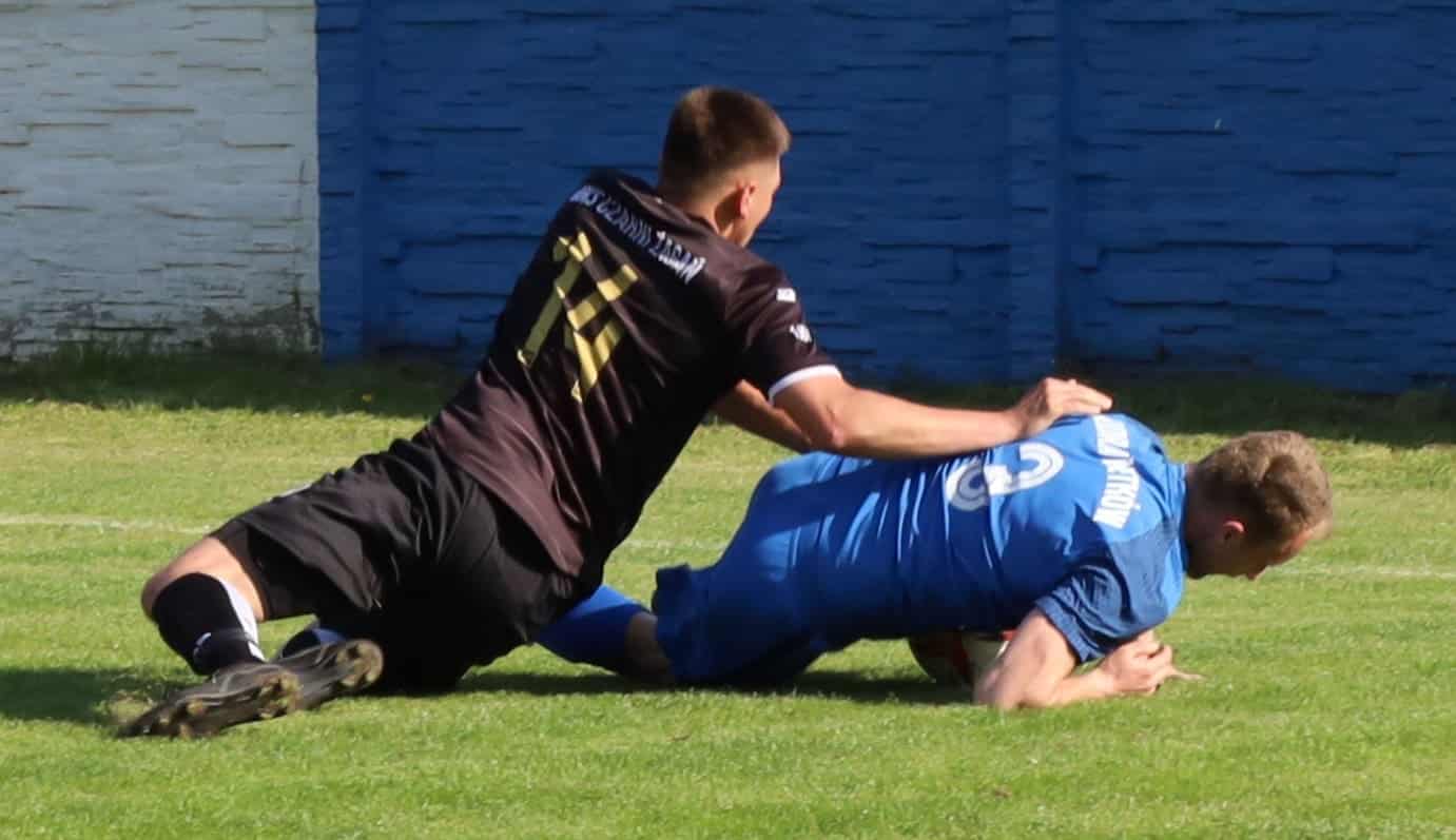 Dwaj mężczyźni leżący na boisku  Odra wysoko wygrywa z Czarnymi Hat trick Patryka Trzmiela ZDJĘCIA