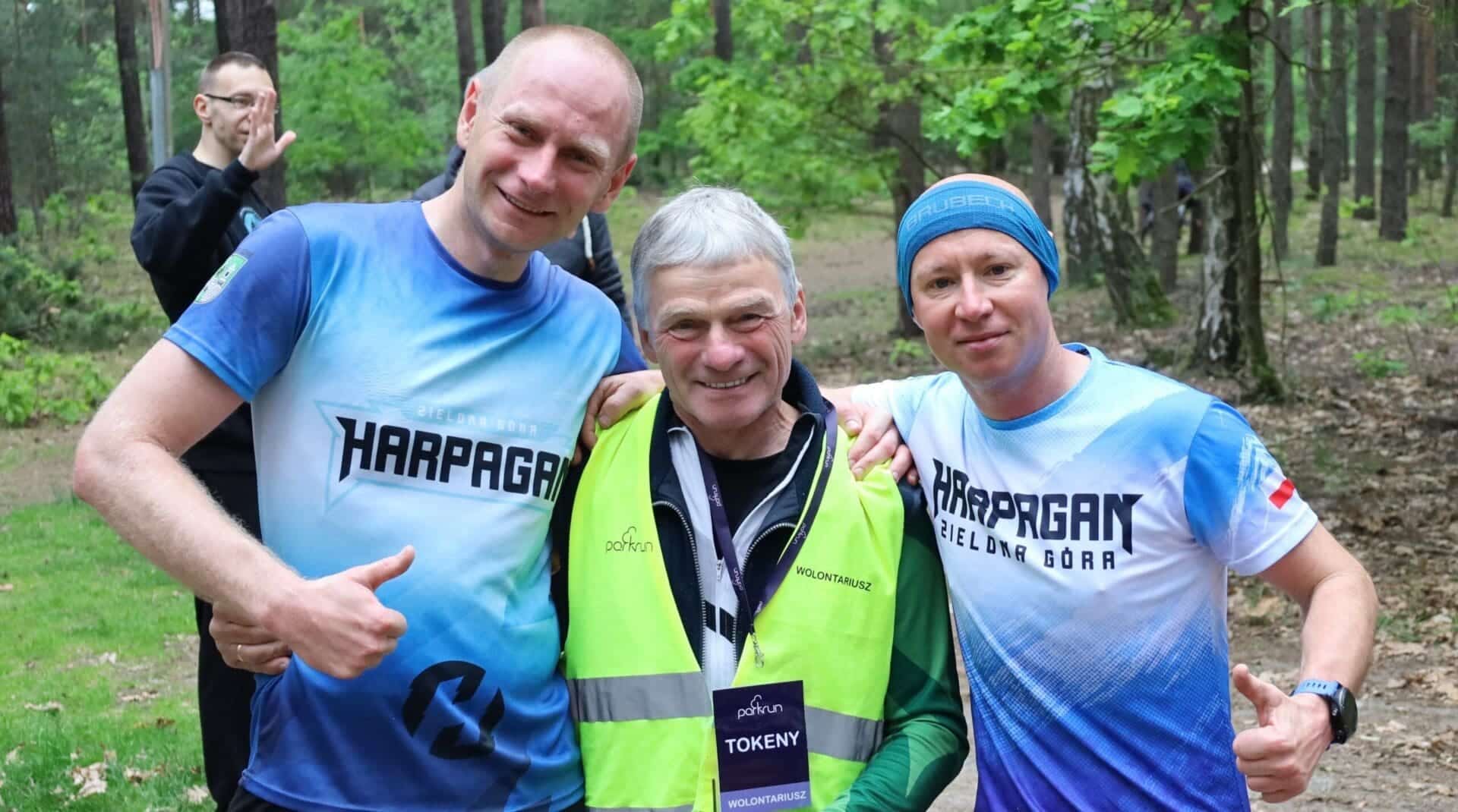 IMG_5339 Trzech uśmiechniętych mężczyzn Parkrun z gościem specjalnym w Zielonej Górze Andrzej Huszcza w roli wolontariusza ZDJĘCIA