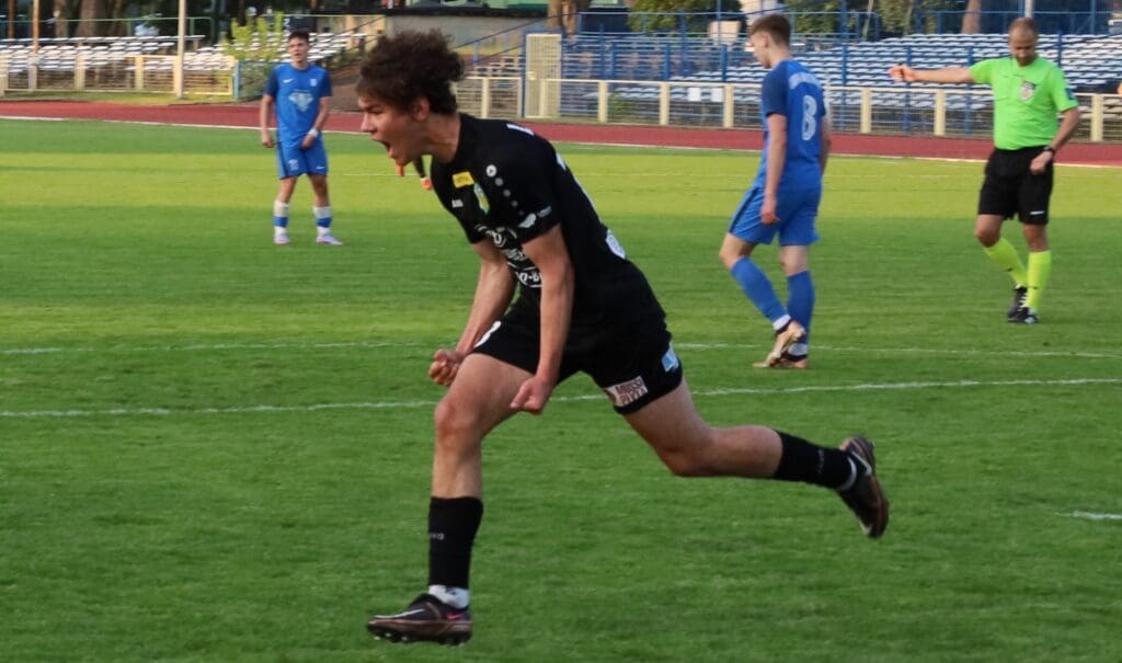 Trzech piłkarzy i sędzia na boisku