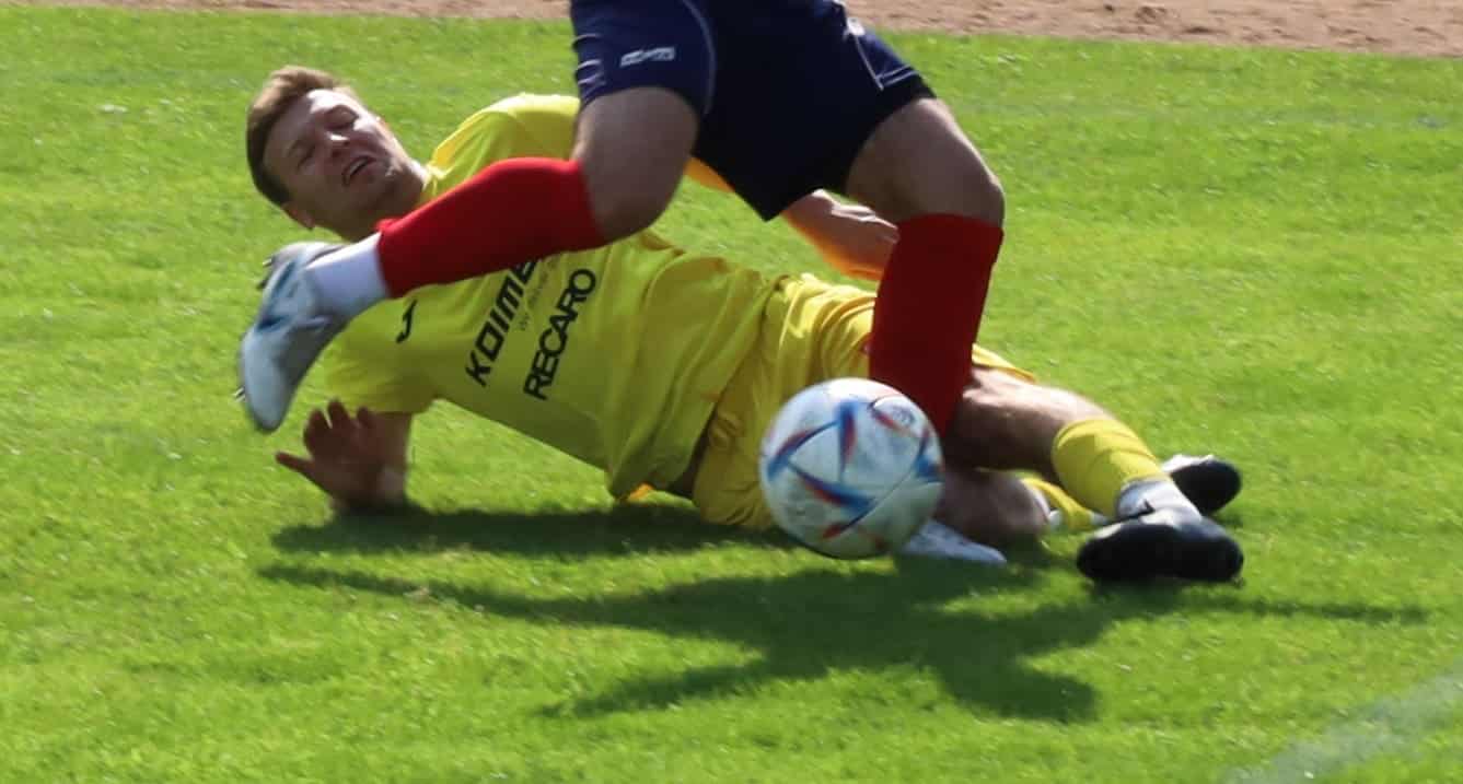 Mężczyzna wchodzący wślizgiem w czasie meczu piłkarskiego  Piłkarski weekend 10 11 czerwca Derby w Gorzowie Stawką utrzymanie TERMINARZ