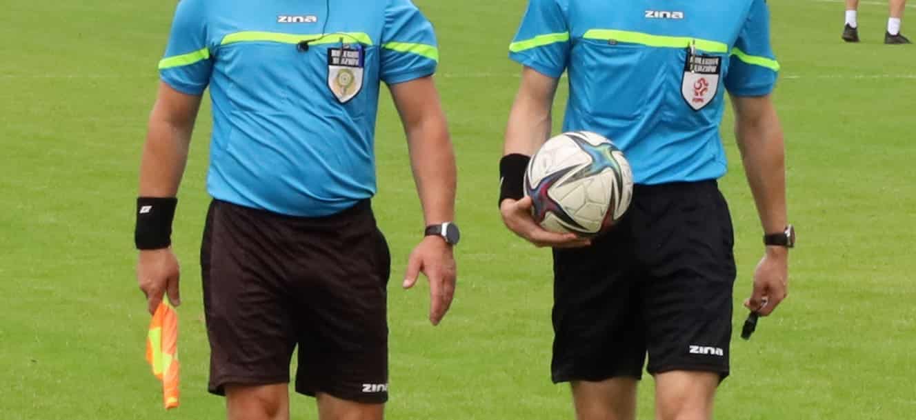 Dwaj sędziowie jeden trzyma piłkę drugi chorągiewkę  Piłkarski weekend 15 17 września Mecze na szczycie w IV lidze i okręgówce WYNIKI