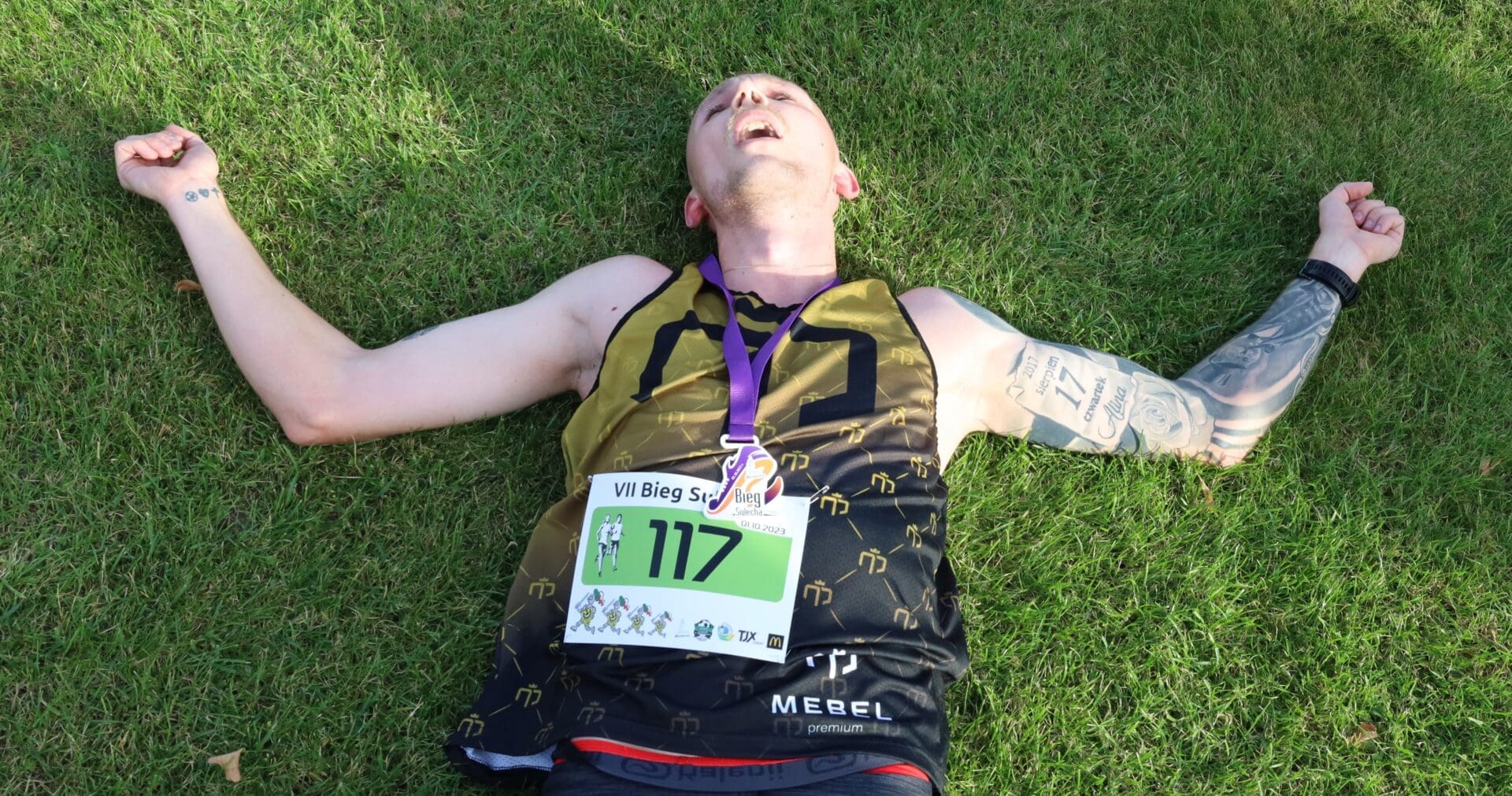 Mężczyzna leżący na trawie  Bieg Sulecha Mocna stawka wartościowe wyniki DUUUŻO ZDJĘĆ