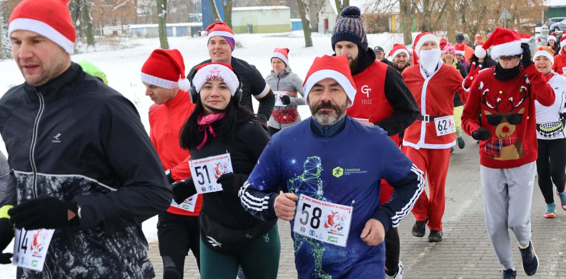 Grupa biegnących osób  Bieg Mikołajkowy w Kalsku Śnieżna sceneria i świąteczny klimat ZDJĘCIA