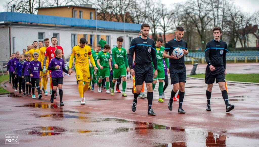 Piłkarze w asyście dziecięcej eskorty