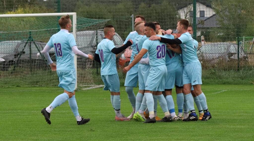 Grupa cieszących się mężczyzn na boisku