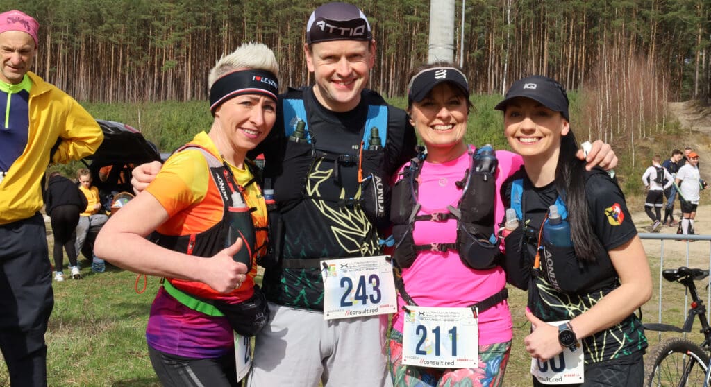 Cztery uśmiechnięte osoby w sportowych strojach