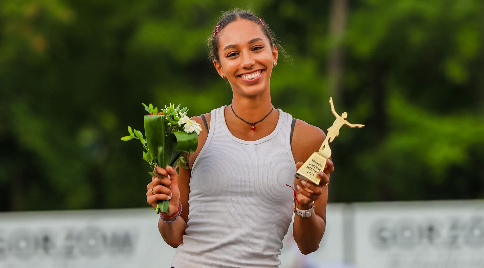 Uśmiechnięta kobieta z bukiecikiem kwiatów i statuetką  Rewelacyjny bieg i życiówka Mariki Majewskiej ZDJĘCIA