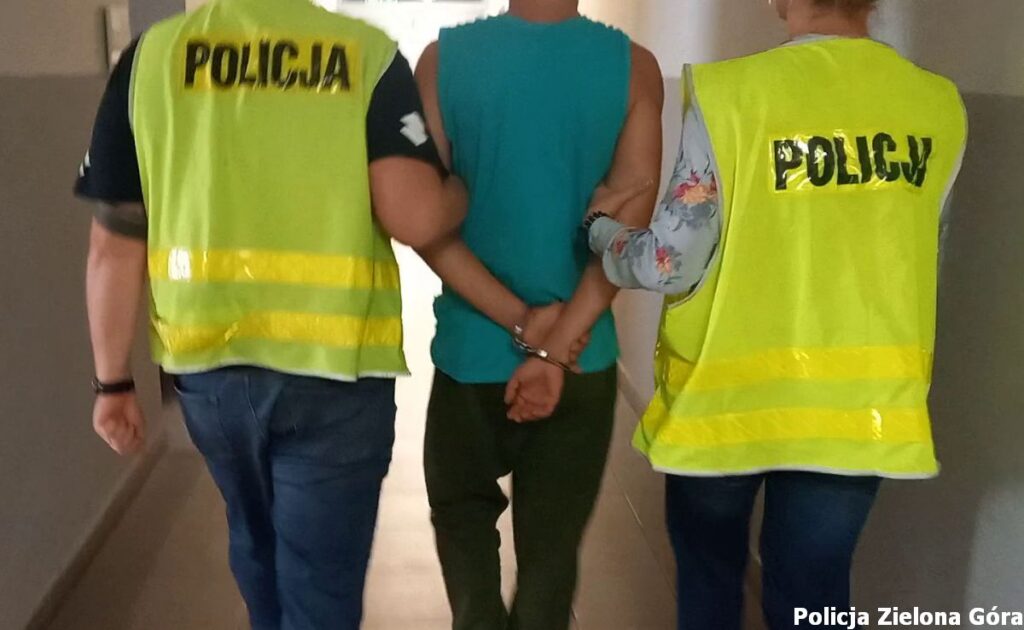 Dwóch policjantów prowadzi skutego podejrzanego.