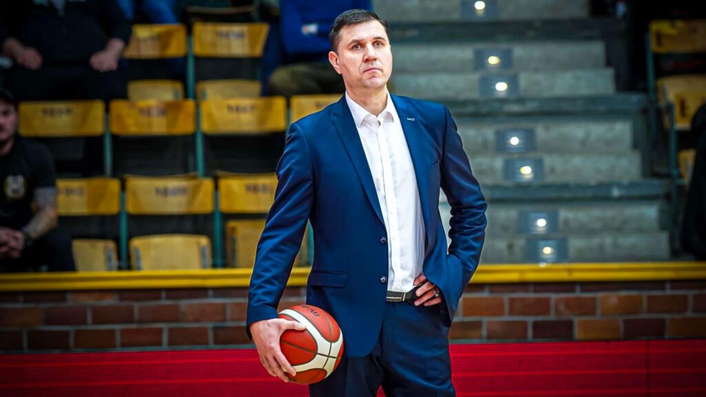 Mężczyzna w garniturze i z piłką do koszykówki