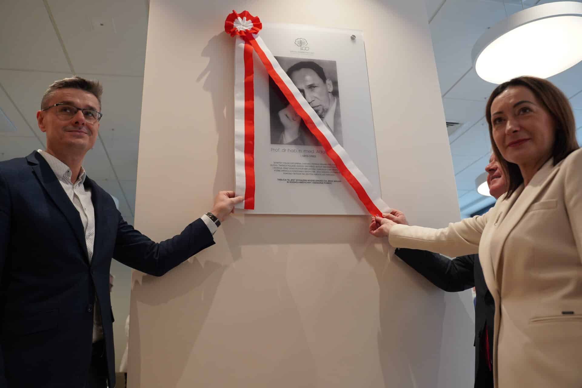 Sebastian Ciemnoczołowski oraz Elżbieta Kozak odsłaniają tablicę Adama Grucy  Świebodzin Szpital rehabilitacyjny zyskał patrona To lekarska legenda WIDEO