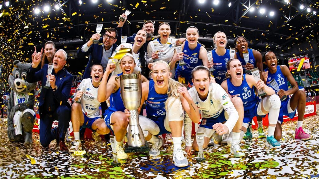 Grupa uśmiechniętych koszykarek z pucharem