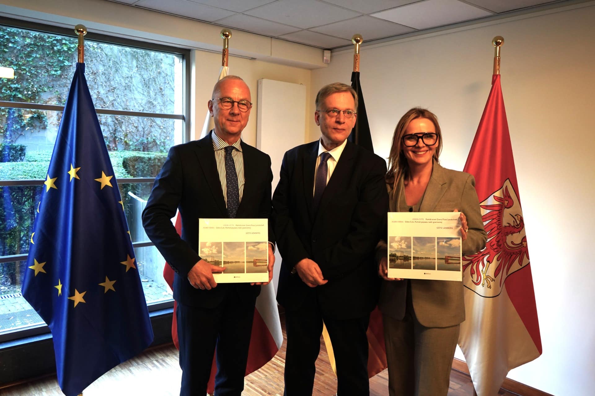 1 Na zdjęciu na tle flag pozują trzy osoby Lubuskie i Brandenburgia chcą normalności