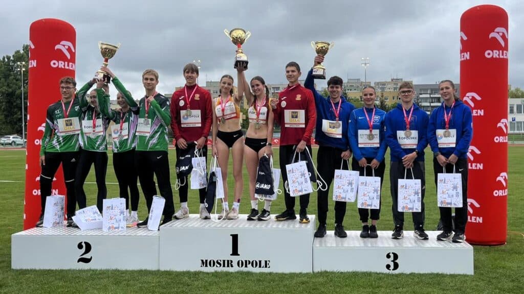 Dwanaście osób w sportowych strojach na podium