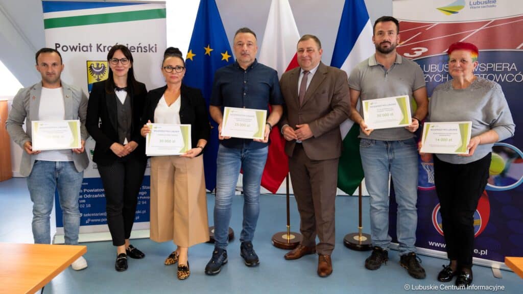 Siedem osób na tle flag