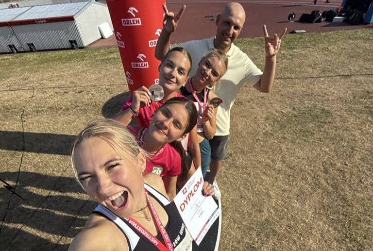 Pięć uśmiechniętych osób z medalami