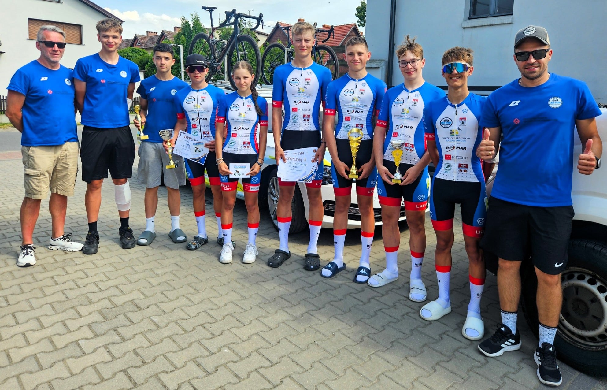 LKS POM Strzelce Krajeńskie Grupa uśmiechniętych osób w sportowych strojach Czekay i Leszkiewicz dwa razy na podium