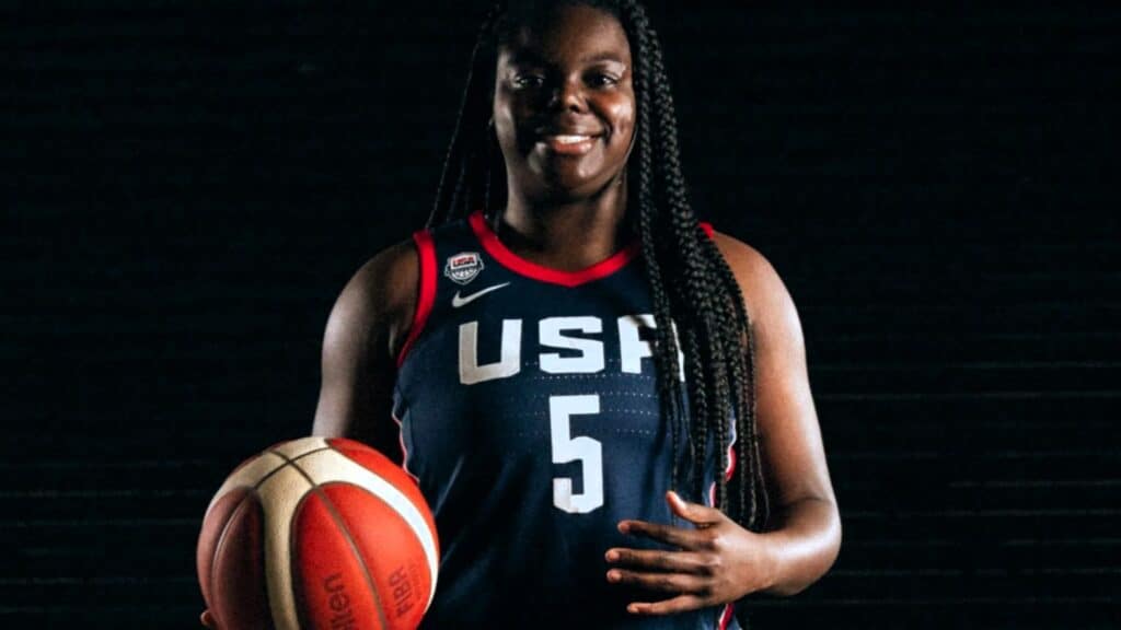 Uśmiechnięta kobieta z piłką do koszykówki