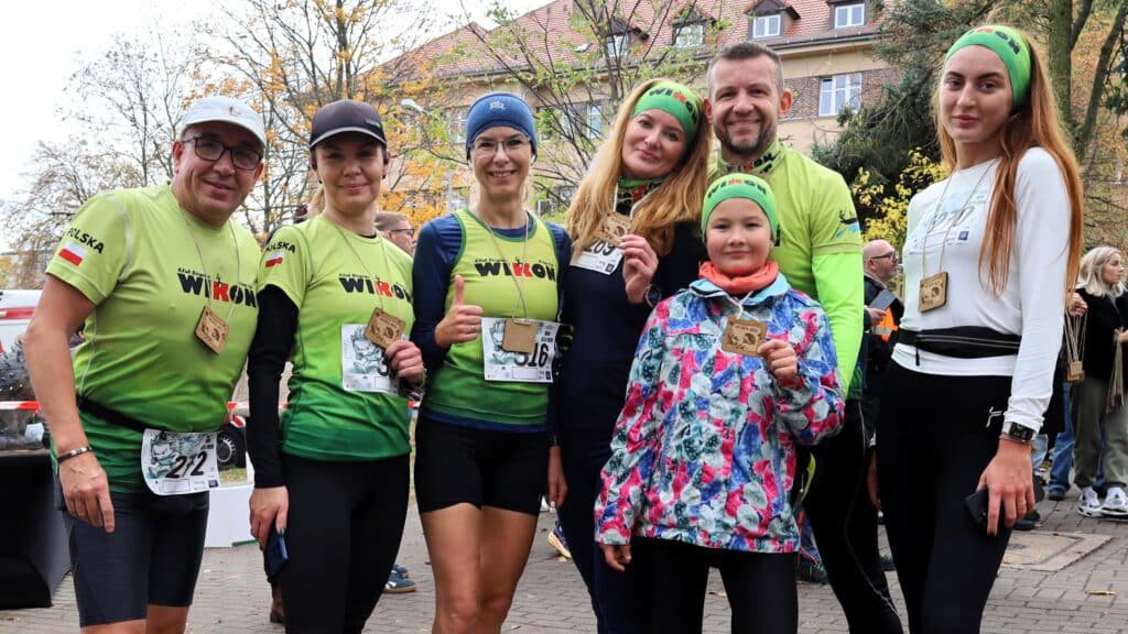 Siedem uśmiechniętych osób w sportowych strojach