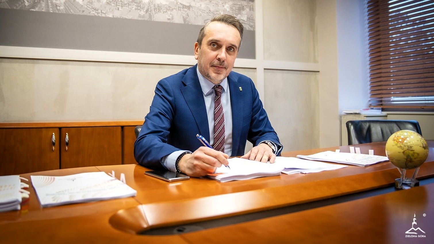 Mężczyzna w garniturze podpisujący dokumenty  Niższe wydatki i niższe dochody w budżecie Zielonej Góry na rok 2026