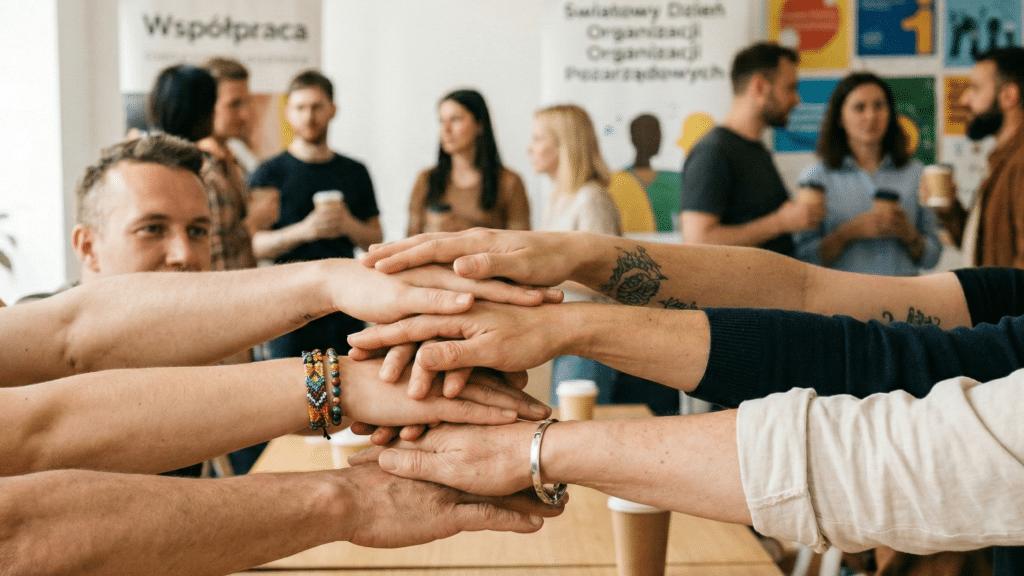 Dłonie leżące jedna na drugiej, symbolizujące współpracę